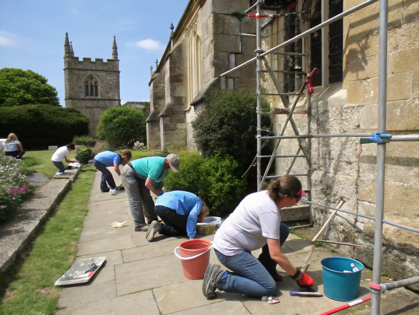 A photograph of a group of volunteers working together to restore a historical site in the Fitou region, emphasizing community involvement and preservation efforts.